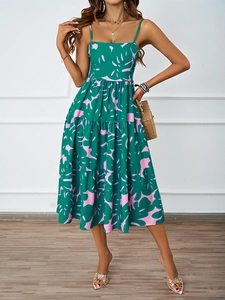 Detail eines tropischen Blumenmusters auf einem grünen Stufenkleid mit Trägern