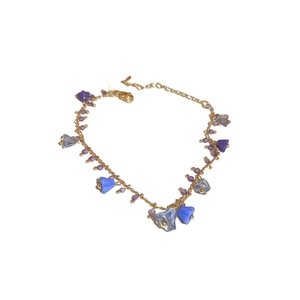 Elegant gold chain necklace featuring purple and blue floral crystal beads on white background