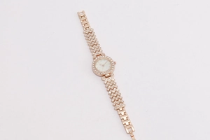 Detail of rose gold ladies watch with crystal encrusted bezel and white dial