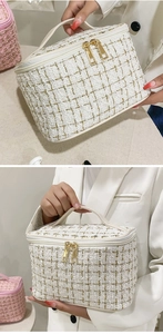 Detail of white tweed makeup bag with gold thread weaving and double zipper closure