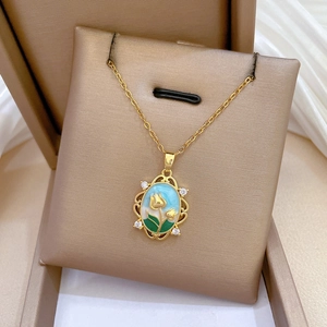 Close-up of golden tulip necklace pendant with blue enamel and crystal inlay in gift box