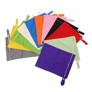 Flat lay of waterproof diaper bags in eleven vibrant colors with snapping hanging straps