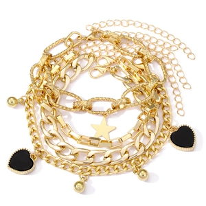 Vintage multi-layer gold bracelet set with star and black heart charms on white background