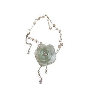 Green floral mesh necklace with pearls and rhinestone accents on a white background