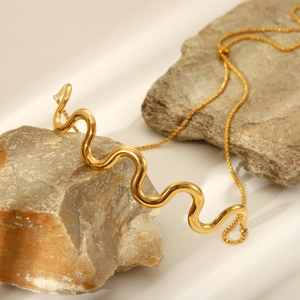 Adjustable wavy 18K gold-plated stainless steel bracelet on a natural stone surface