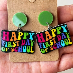 Colorful Happy First Day of School teardrop earrings on a cardboard holder