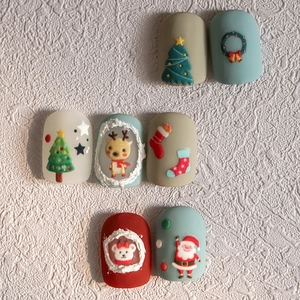 Christmas nail art stickers featuring Santa Claus and reindeer on a white surface