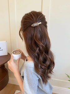 Barrette française en acétate avec strass sur base marron portée sur des cheveux bouclés