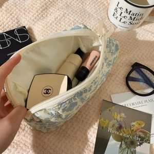 Detail showing soft quilted floral cosmetic bag interior with makeup storage capacity