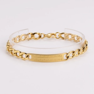 Macro shot of gold Cuban chain bracelet featuring an engraved Greek key pattern plate