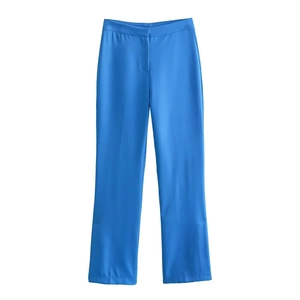 Detail of high-waist bright blue trousers with side slits and smooth suit fabric