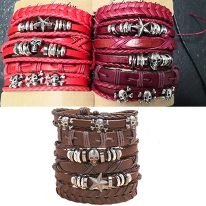 Macro detail of braided leather bracelets set with metal skull and star charms