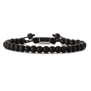 Detailed close-up of matte black volcanic stone beads and metal plaque on woven bracelet