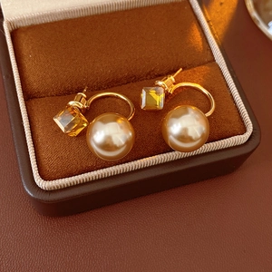 Detailed view of French vintage pearl earrings with yellow square gemstone in jewelry box