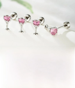 Detail view of pink zircon heart piercing jewelry with silver titanium steel backings