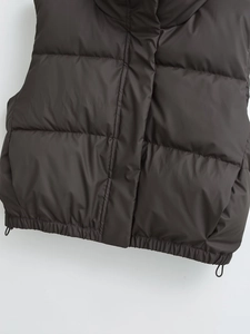 Detail of dark brown puffer vest featuring adjustable hem drawstring and quilted texture