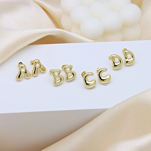 Polished gold alphabet bubble stud earrings letters ABCD on elegant silk background