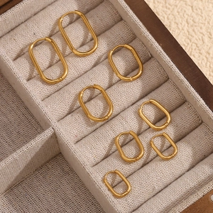 Detailed set of gold plated oval hoop earrings in different sizes displayed in a box