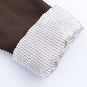 Detailed macro view of brown suit cuff showing fine black and white striped lining detail