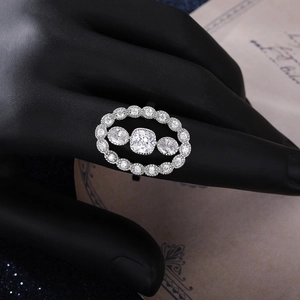 Macro shot of silver cushion-cut ring with three stones and halo accents on model
