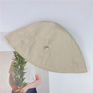 Detailed top view of a beige bucket hat with a silver metal ring and stitch detailing