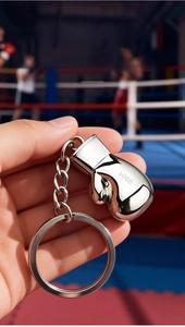 Macro view of mirror-polished silver boxing glove keychain with customizable logo area