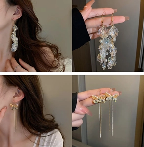 Close-up of floral pearl earrings with long tassels and crystal butterfly details