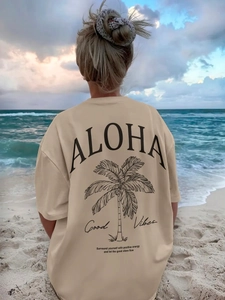 Oversized μπεζ βαμβακερό t-shirt με τύπωμα φοίνικα ALOHA σε φόντο παραλίας στο ηλιοβασίλεμα