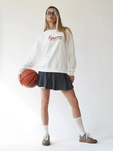 Set donna felpa bianca e minigonna a pieghe per uno stile sportivo e casual moderno