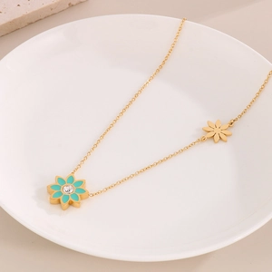 Détail du collier à fleurs dorées avec pétales en émail bleu et centre en cristal