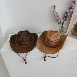 Detailed shot of two mesh straw cowboy hats in brown and tan with adjustable chin cords