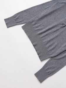 Detailed macro view of gray knitted polo sweater featuring ribbed hem and buttoned placket