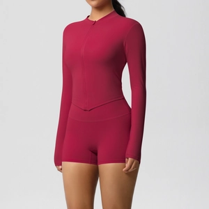 Detail of magenta zip-up yoga jacket with V-hem and high-waisted fitness shorts