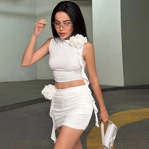 Sexy white two-piece set with sleeveless crop top and high-waist mini skirt with 3D floral detail