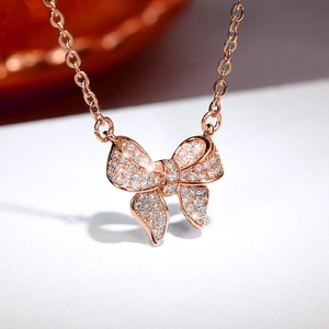 Macro shot of rose gold bow pendant necklace with micro-paved cubic zirconia