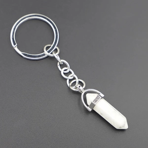 Macro shot of white hexagonal crystal pillar keychain with silver metal mount and grey veins