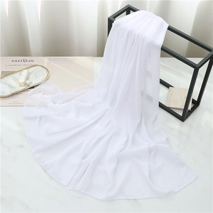 Macro shot of pure white pearl chiffon scarf draped elegantly over a black metal rack