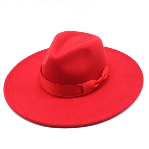 Close-up of red wide brim fedora hat with matching ribbon bow and classic C-crown