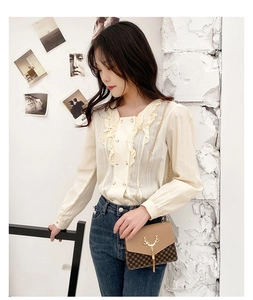 Detail of elegant cream blouse with ruffle collar and textured vertical stripes