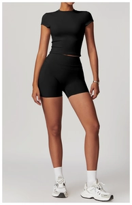 Full body view of women's black slim fit yoga set with crop top and high waist shorts
