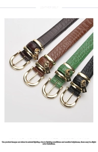 Detailed view of leather belts with crocodile pattern and golden horseshoe buckles