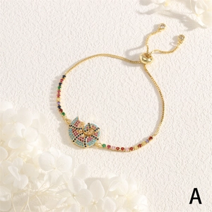 Detail of adjustable gold shell bracelet with multi-colored stones and a sliding clasp