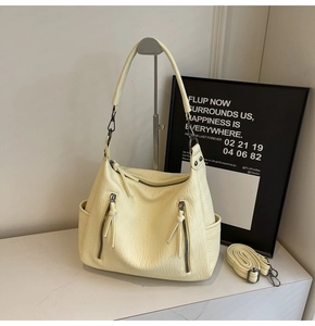 Detail view of cream hobo bag showing soft lychee leather texture and metal zipper