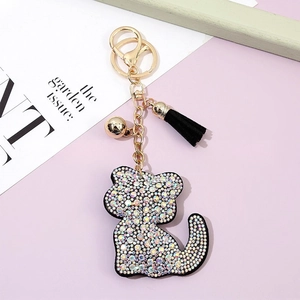 Cartoon crystal cat keychain with sparkling rhinestones and black tassel on bicolour background