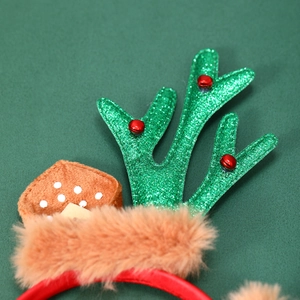 Gros plan d'un serre-tête bois de renne avec paillettes vertes et cloches rouges