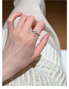 Close-up of S925 silver pearl ring with a blue flower and sparkling crystal pendant
