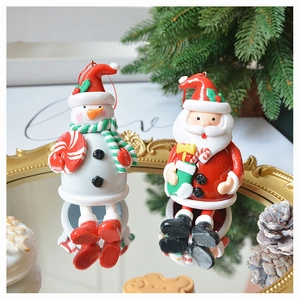 Detailed view of 3D polymer clay Santa and snowman ornaments on a gold mirror tray