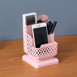 Pink rectangular desk organizer with woven texture holding remote, phone, and stationery