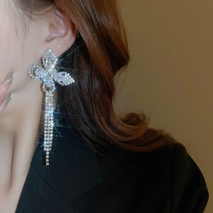 Detailed close-up of a shimmering butterfly tassel earring with cubic zirconia and silver plating