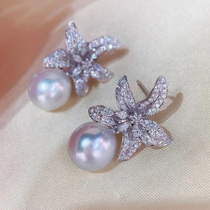 Macro shot of elegant starfish earrings with zircon micro-pave and round white pearls